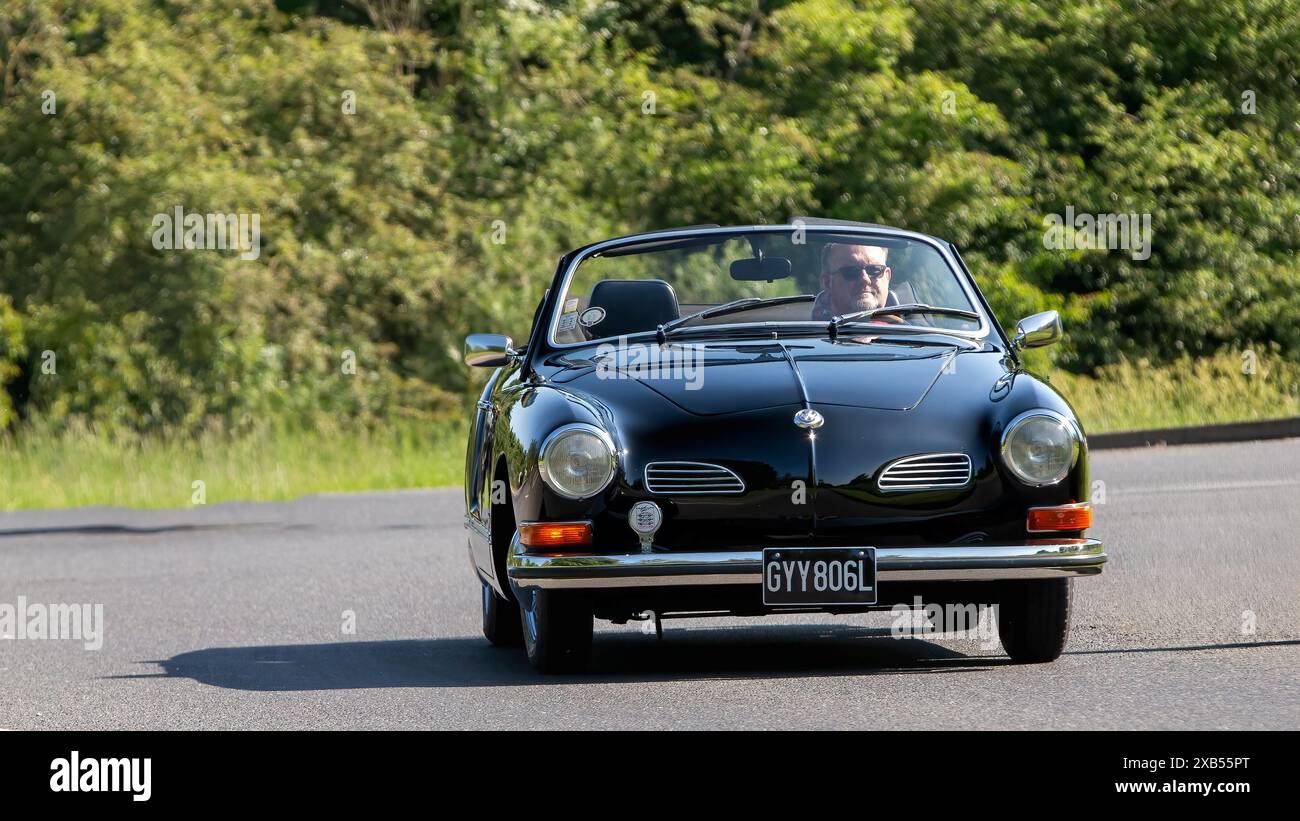 Stony Stratford, UK - 2. Juni 2024: 1973 schwarzer Volkswagen Karmann ghia Oldtimer fährt auf einer britischen Landstraße Stockfoto