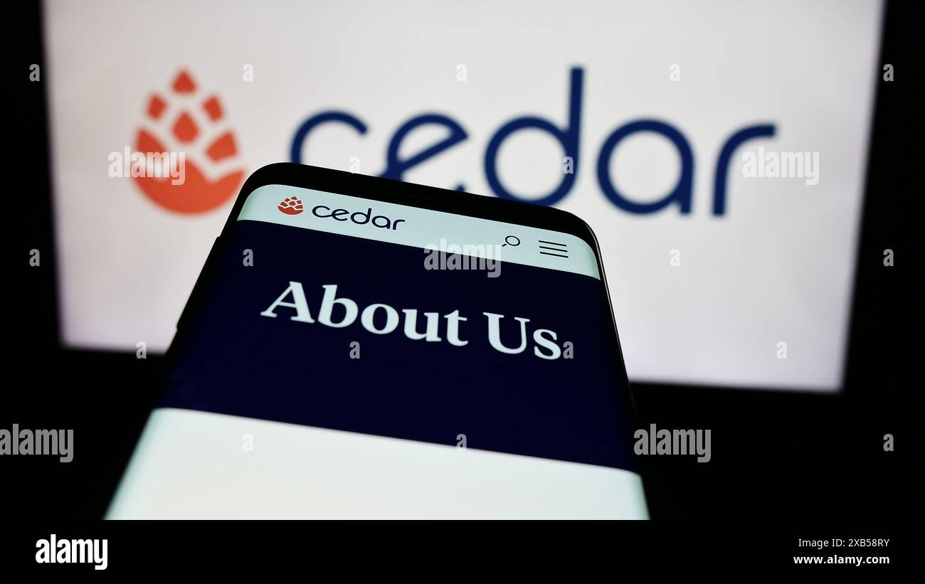 Mobiltelefon mit Website des US-amerikanischen Softwareunternehmens Cedar Cares Inc. Vor dem Geschäftslogo. Fokussieren Sie sich oben links auf der Telefonanzeige. Stockfoto