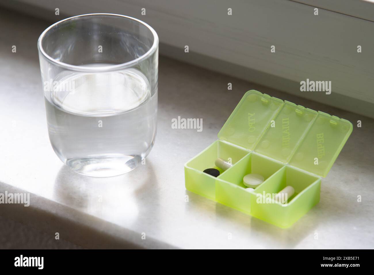 Pille Box mit verschiedenen Pillen und Nahrungsergänzungsmittel, Pillen Organizer und Glas Wasser Stockfoto
