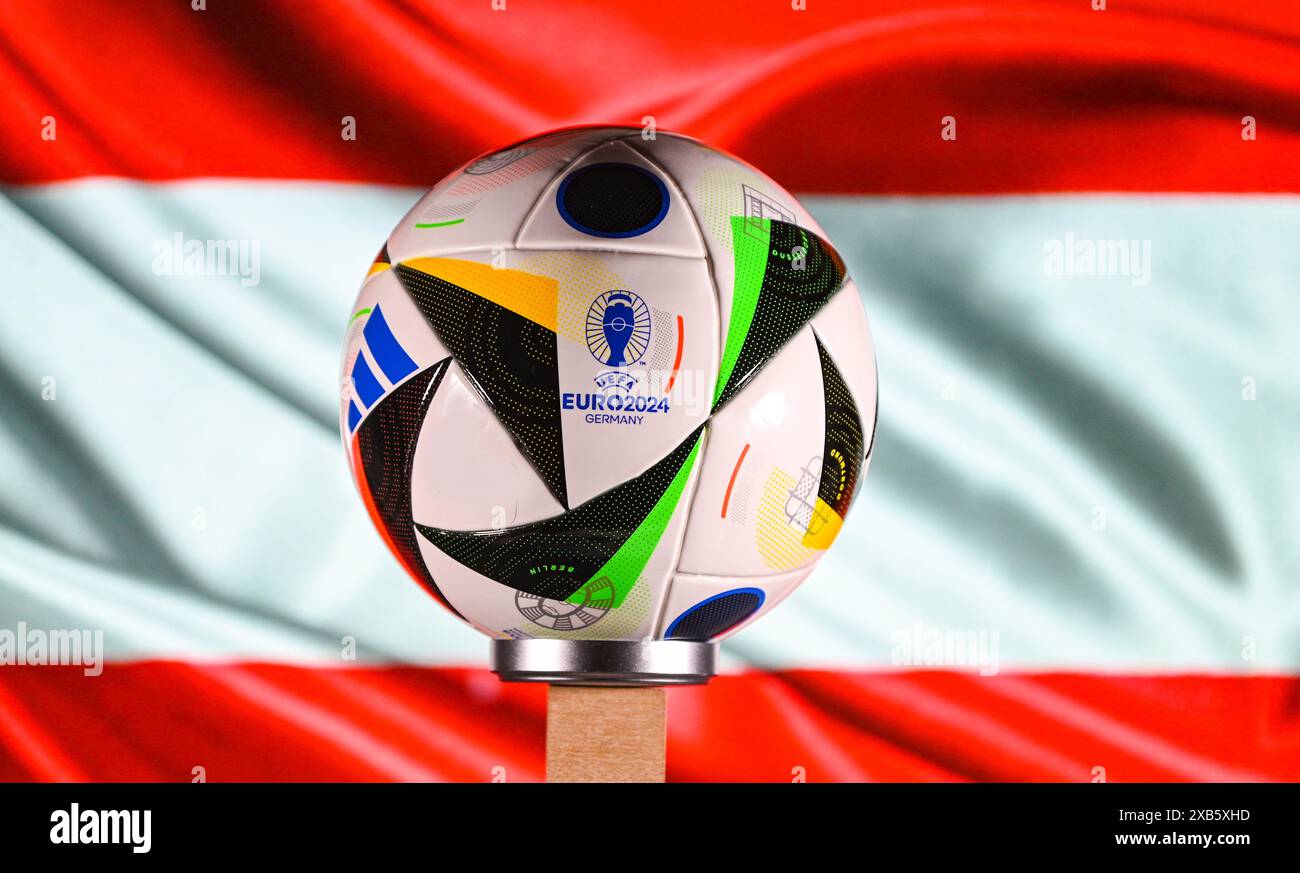 Juni 2024, Berlin, Deutschland. Der offizielle Euro 2024 Adidas Fussballliebe Ball auf dem Hintergrund der Flagge Österreichs. Stockfoto