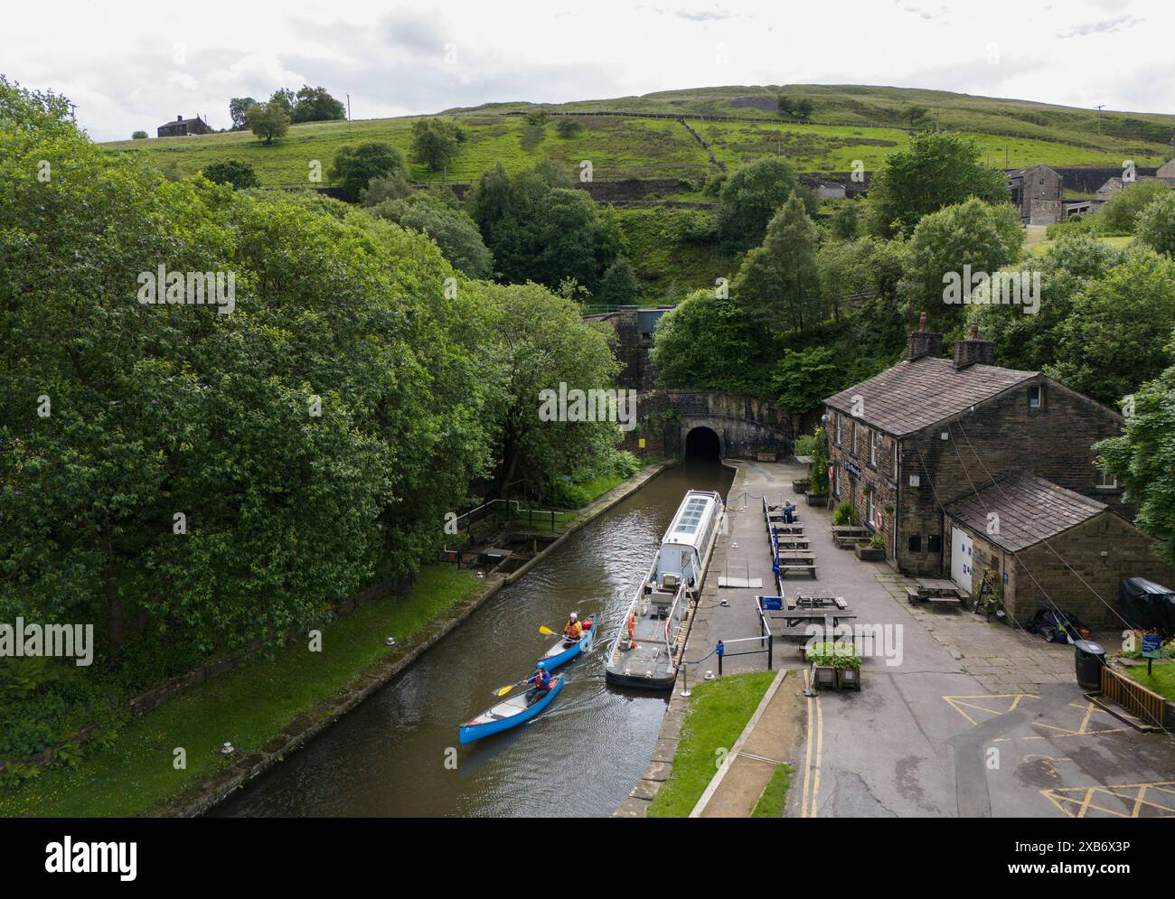 Kanufahrer verlassen den Standedge Tunnel auf dem Huddersfield Narrow Canal, der als eines der sieben Wunder der britischen Wasserstraßen beschrieben wird: Der Tunnel, der fast dreieinhalb Meilen lange, über 17 Jahre dauerte, um von Hand zu graben, wurde 1811 fertiggestellt und wurde mit 645 Fuß über dem Meeresspiegel zum längsten, tiefsten und höchsten Kanaltunnel Großbritanniens, der etwa 638 Meter unter den Pennines grub. Bilddatum: Montag, 10. Juni 2024. Stockfoto