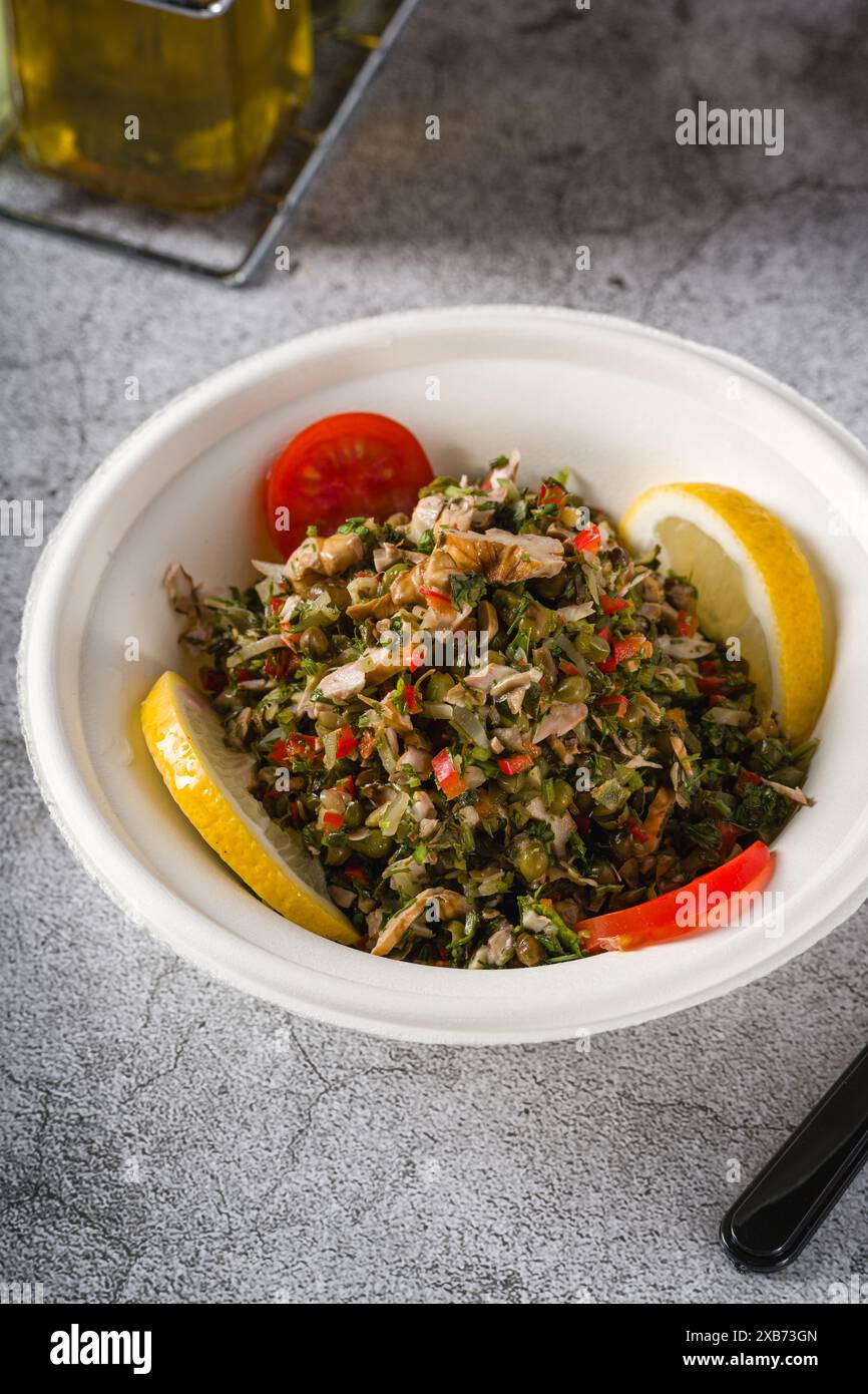 Gesunder Salat mit Kapern, Quinoa und Walnüssen auf Steintisch Stockfoto