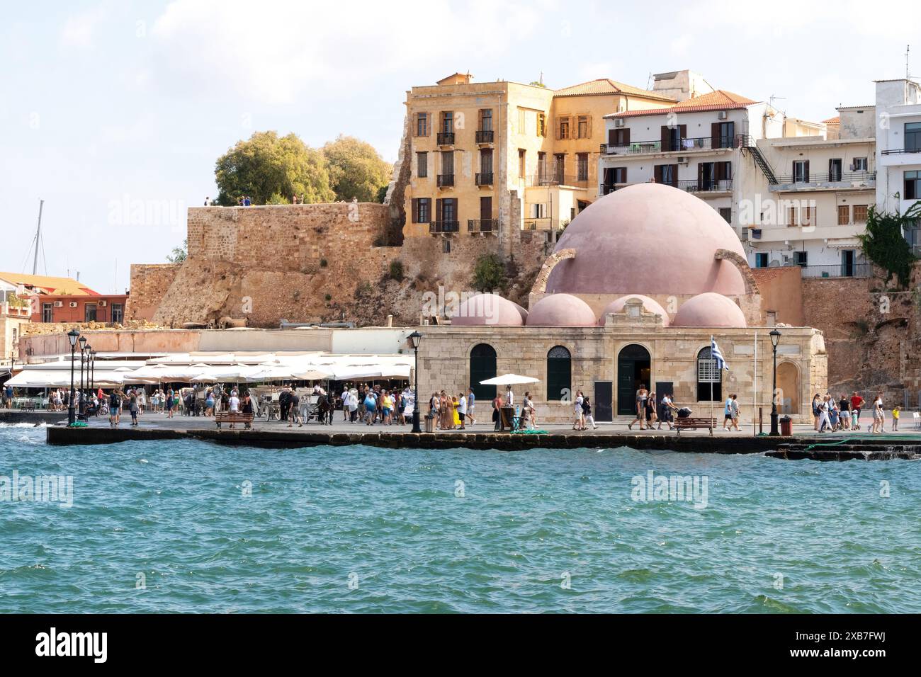 Touristen am Hafen gehen vorbei an der Kucuk Hasan Moschee, Chania, Kreta, Griechenland Stockfoto