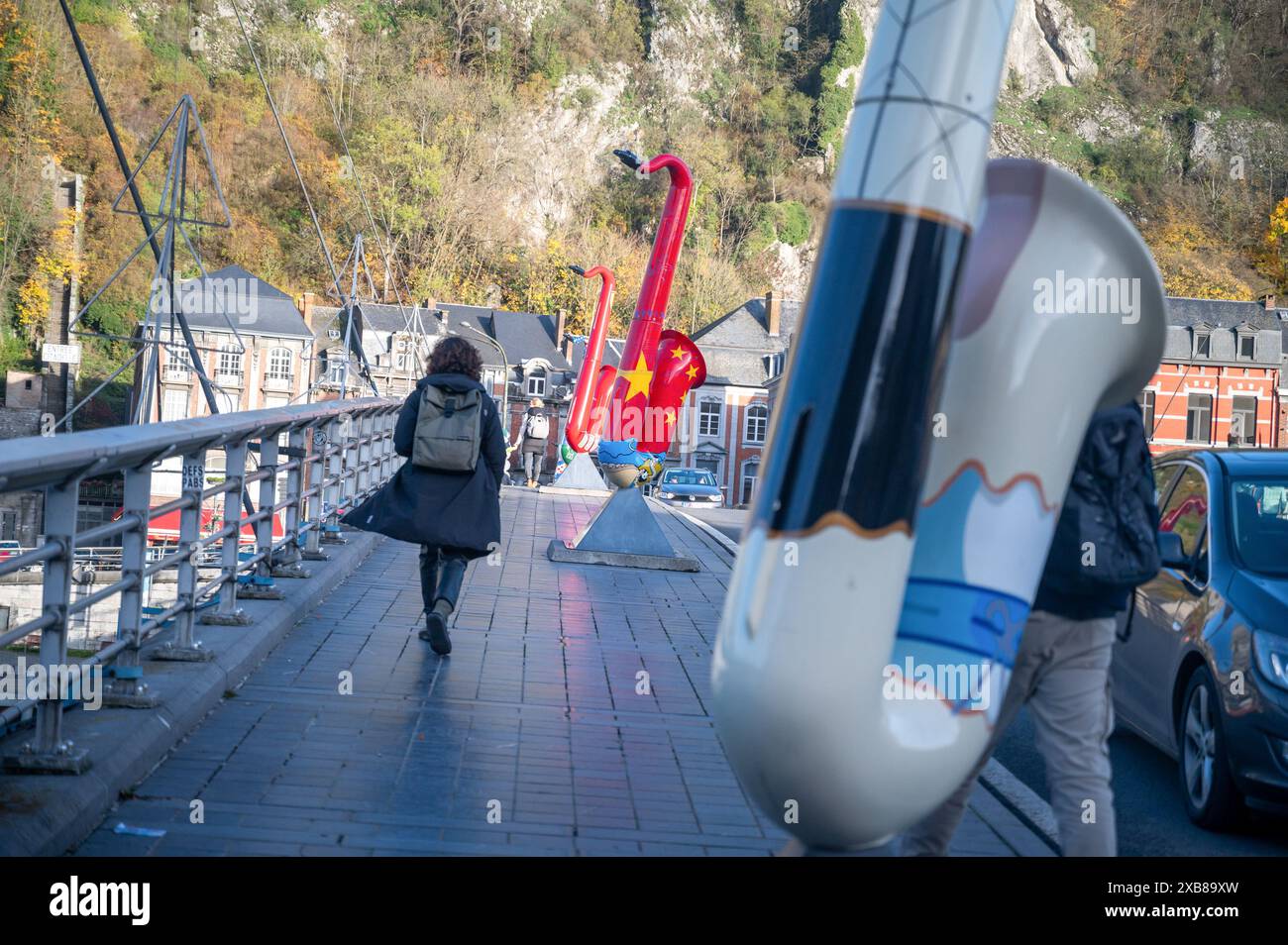Frau in schwarzer Jacke, die auf einer Brücke neben einer Gitarre schlendert Stockfoto