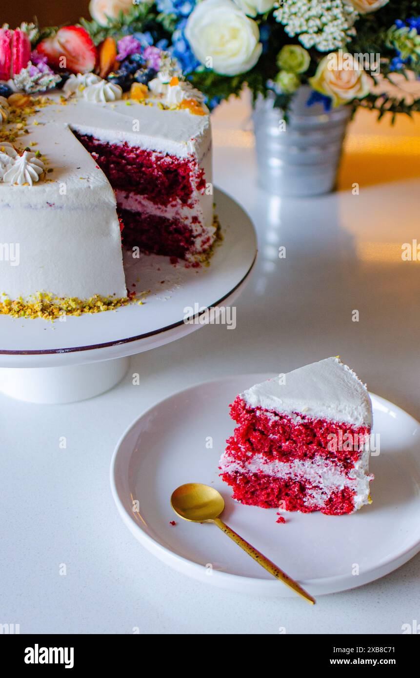 Weißer Kuchen mit roten und weißen Blumen auf einem Tisch Stockfoto