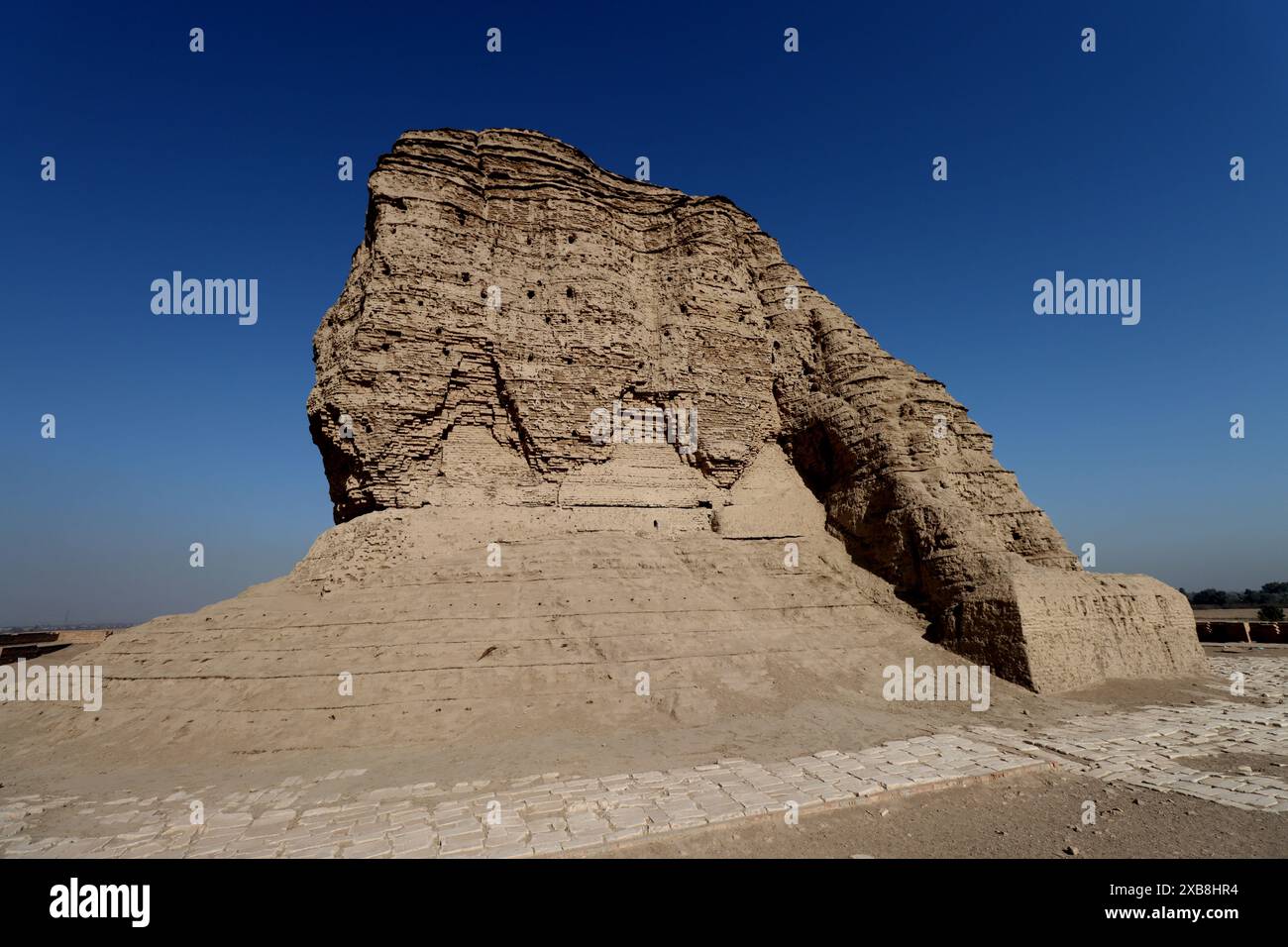 Der Ziggurat von Akarkuf und ein großer Felsbrocken unter einem klaren blauen Himmel in Bagdad. Stockfoto