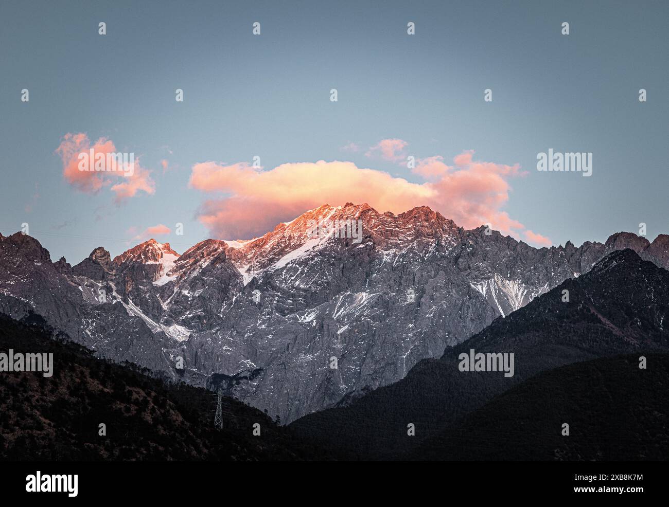 Die Sonne untergeht hinter dem schneebedeckten Berg Stockfoto
