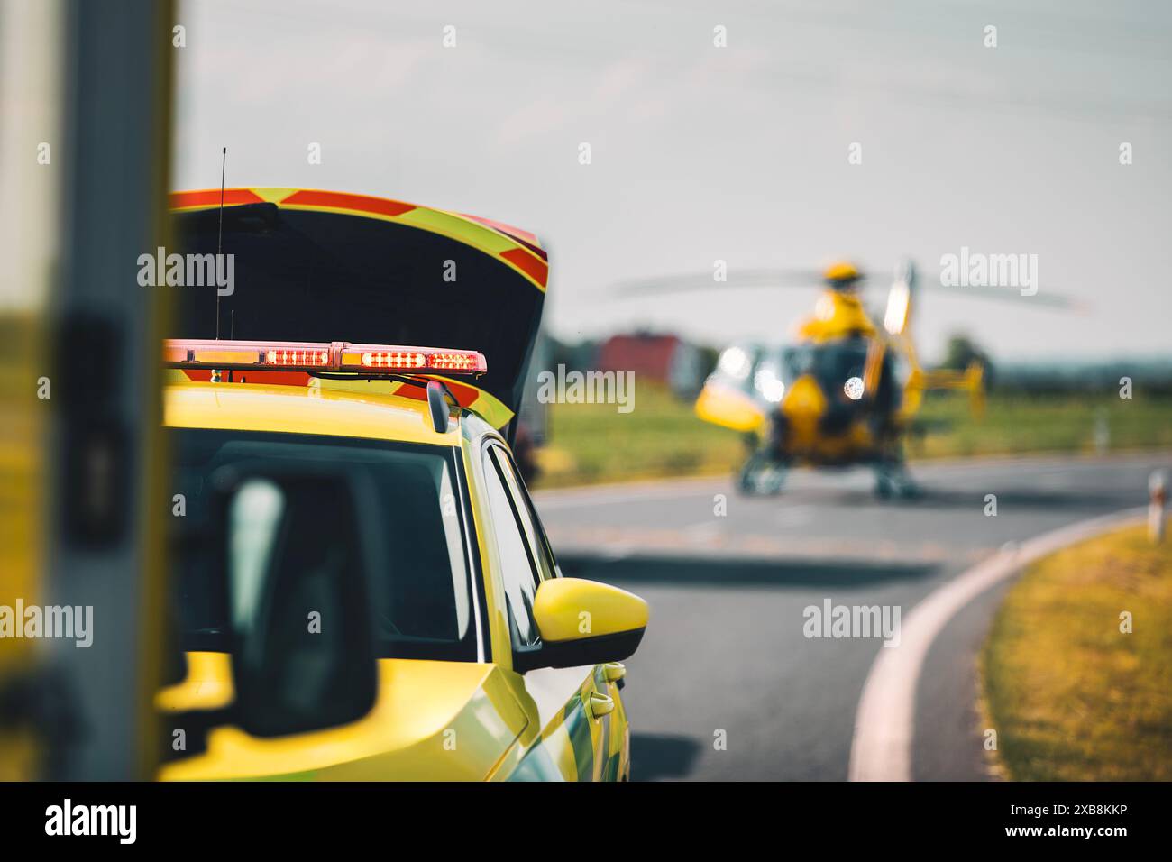 Selektiver Fokus auf Rotlichtblinker auf dem Dach des Ambulanzwagens des Rettungsdienstes gegen Hubschrauberlandung auf der Straße. Themen Rettung, Dringlichkeit Stockfoto