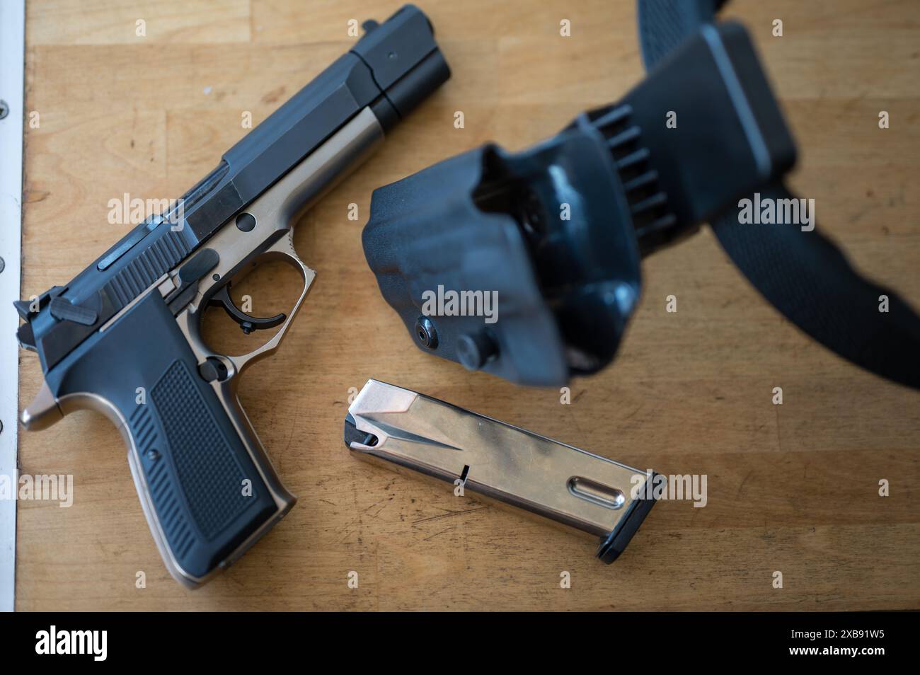 Detail der 9-mm-Pistole mit einem Magazin neben dem Polizeiholster und dem IPSC-Gürtel Stockfoto