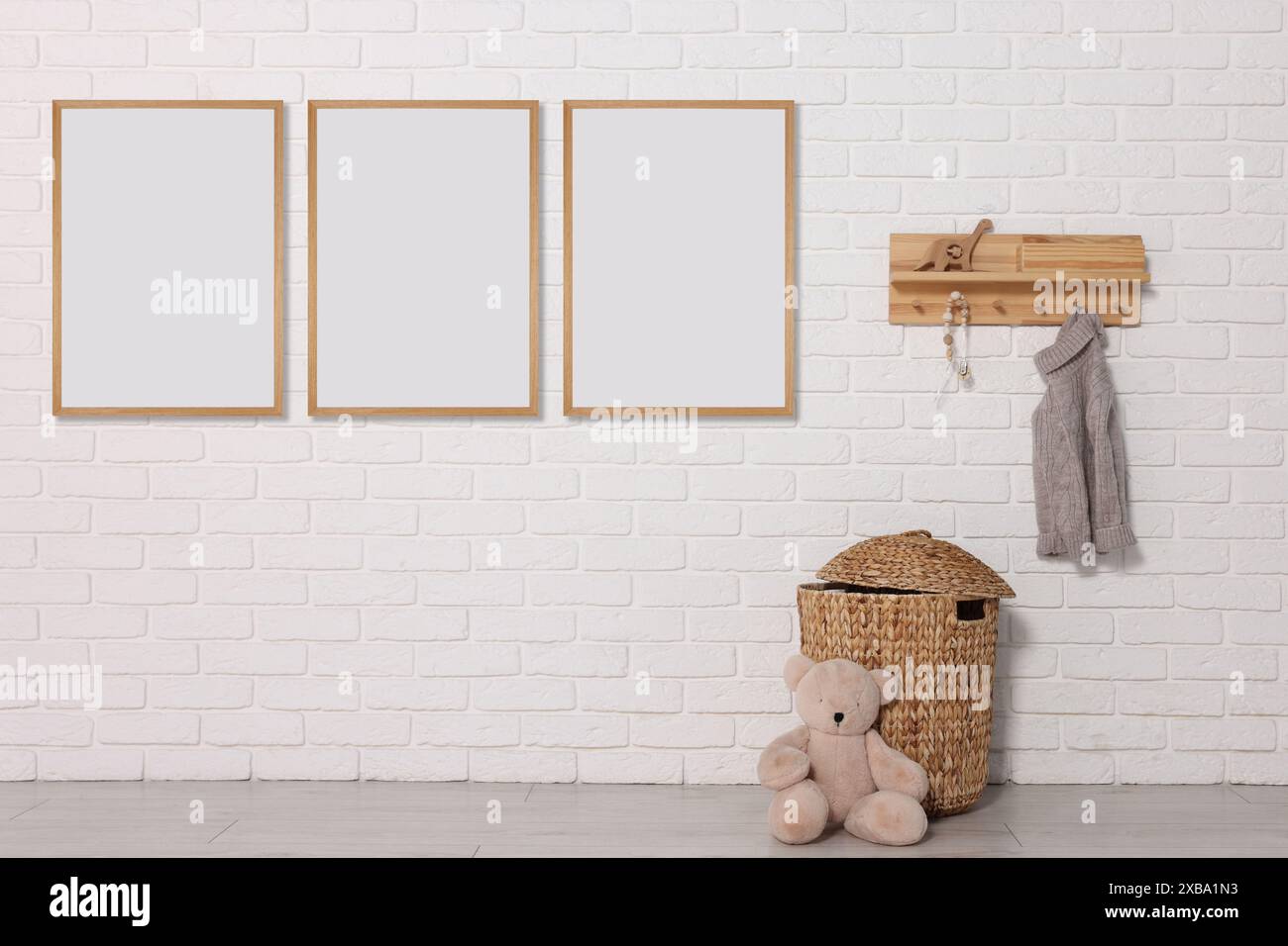 Zimmer für Kinder mit leeren Bildern an weißer Ziegelwand. Innenarchitektur Stockfoto