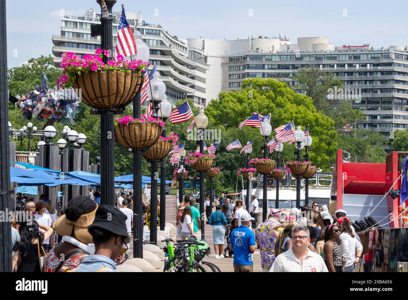 Eine Menschenmenge an einem belebten Ufer mit amerikanischen Flaggen und Blumen in Washington, D.C. Stockfoto