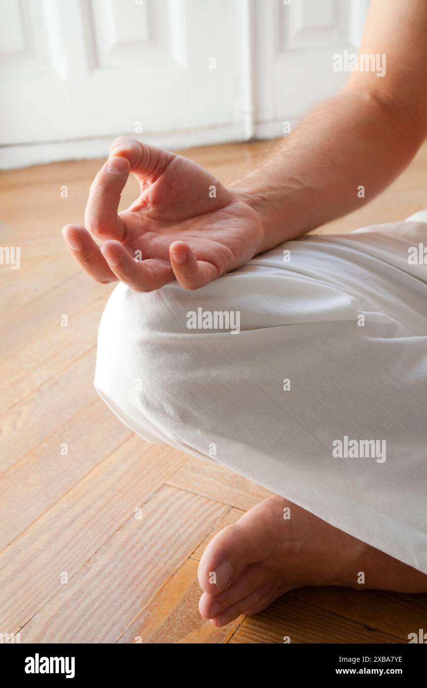 Man Yoga praktizieren, sitzen im Lotussitz. Schließen Sie die Ansicht. Stockfoto