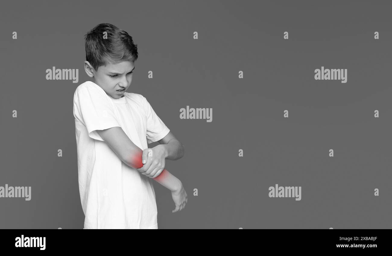 Junge mit Ellbogen mit Schmerzausdruck Stockfoto