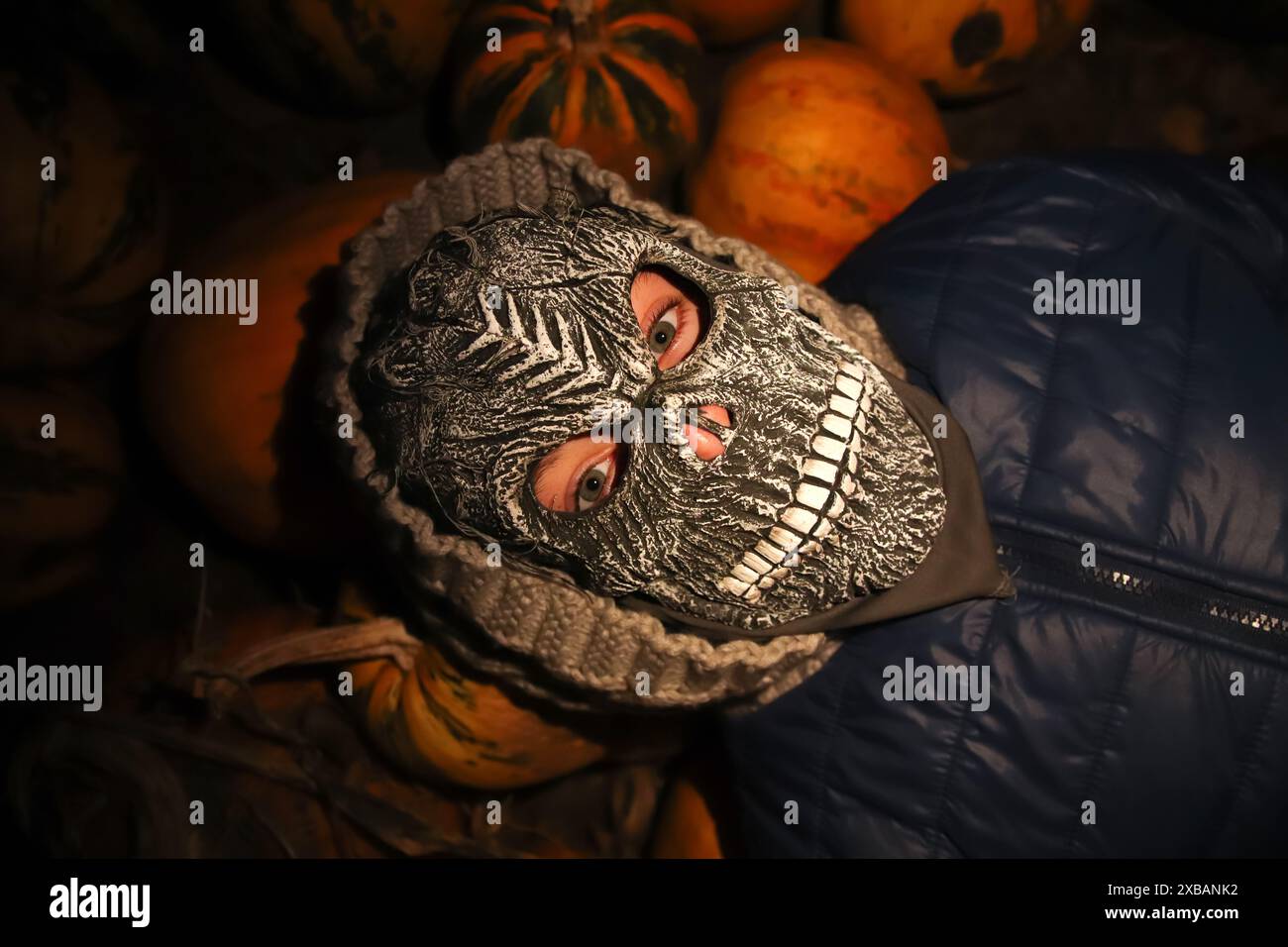 Halloween-Leute. Person in grimmiger Sensenmaske. Gruselige Halloween-Maske bei Nacht. Halloween Kürbisse im Dunkeln. Stockfoto