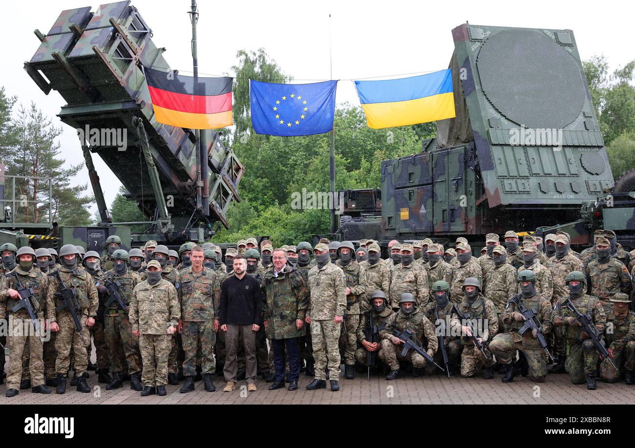 Deutschland. Juni 2024. Volodymyr Selenskyj (Zentrum l), Präsident der Ukraine, und Boris Pistorius (SPD, M), Bundesverteidigungsminister, stehen zusammen mit deutschen und ukrainischen Soldaten bei ihrem Besuch in einem militärischen Übungsgebiet vor "Patriot"-Flugabwehrraketensystemen. Die internationale Wiederaufbaukonferenz für die Ukraine findet am 11. Und 12. Juni statt. Quelle: Jens Büttner/dpa/Alamy Live News Stockfoto
