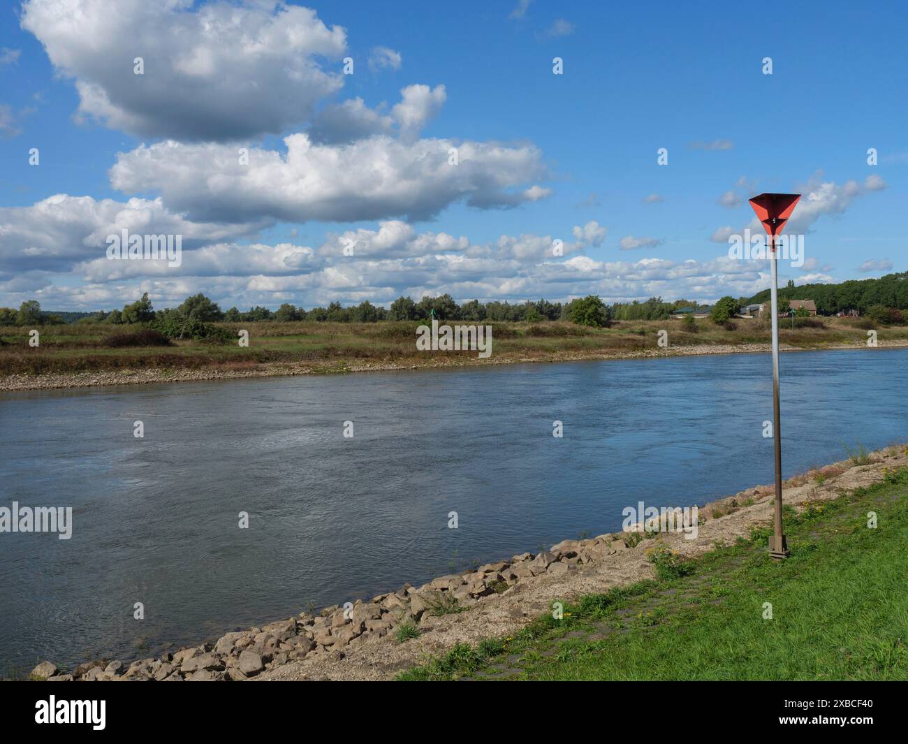 Fluss und Fluss mit Pfosten unter bewölktem Himmel, Doesburg, Gelderland, Niederlande Stockfoto