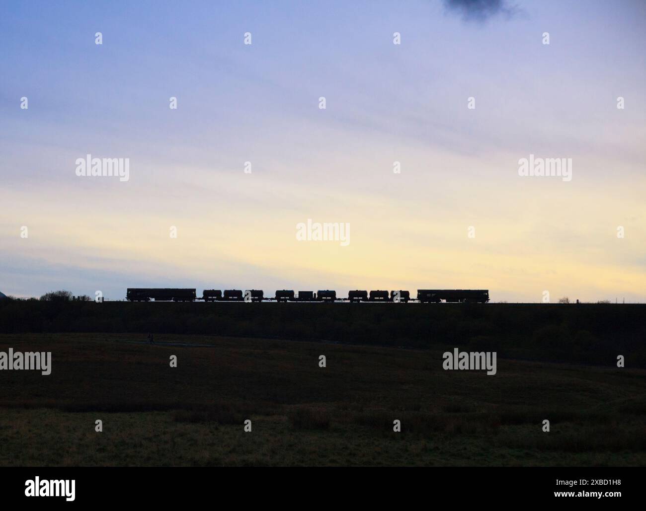 2 Lokomotiven der Baureihe 66 passieren den Sonnenuntergang von Ribbleheadat mit einem Netz der Bahnkopfaufbereitungszüge, der Herbstlaub entfernt Stockfoto