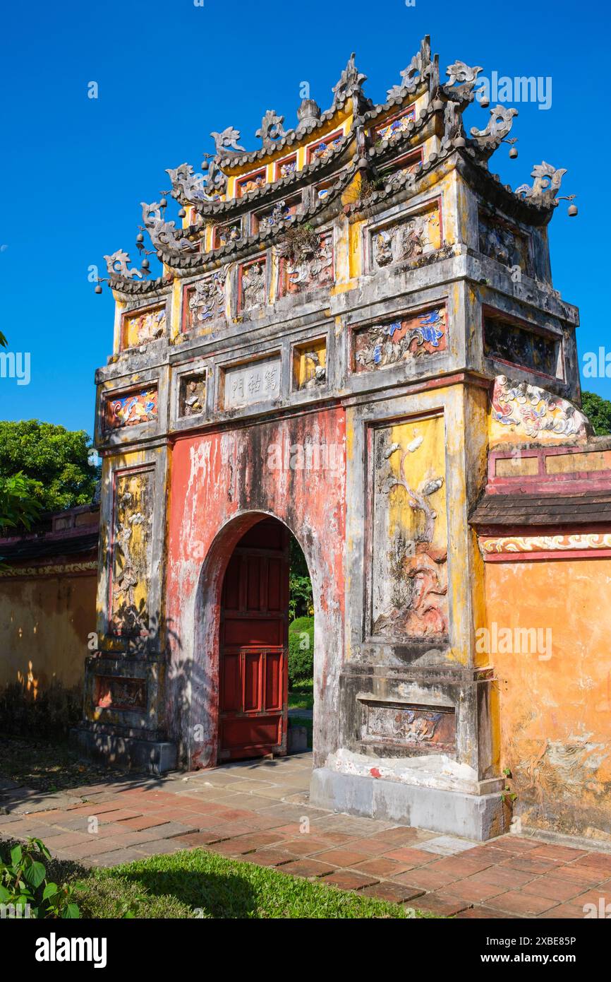 Vietnam: Ein Tor, das aus dem Thế Miếu (dem Mieu)-Tempel führt, die Kaiserstadt, die Zitadelle, Hue. Der Thế Miếu ist ein Ahnentempel, der 1822–23 auf Befehl von Kaiser Minh Mạng errichtet wurde. Er ehrt die Kaiser der Nguyễn-Dynastie. Kaiser Gia Long ordnete 1805 den Bau der Zitadelle von Hue an. Der weitläufige Komplex wurde nach den Vorstellungen des Fengshui oder der chinesischen Geomanz errichtet, aber nach den militärischen Prinzipien des bekannten französischen Militärarchitekten Sebastien de Vauban aus dem 18. Jahrhundert. Stockfoto