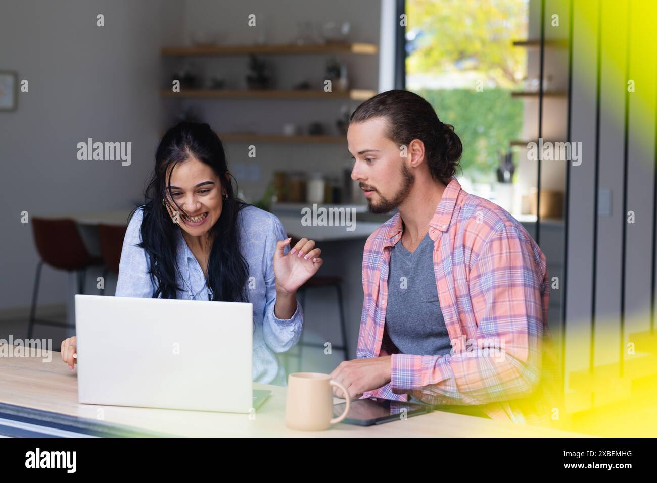 Ein junges, vielseitiges Paar sieht sich zusammen einen Laptop an Stockfoto