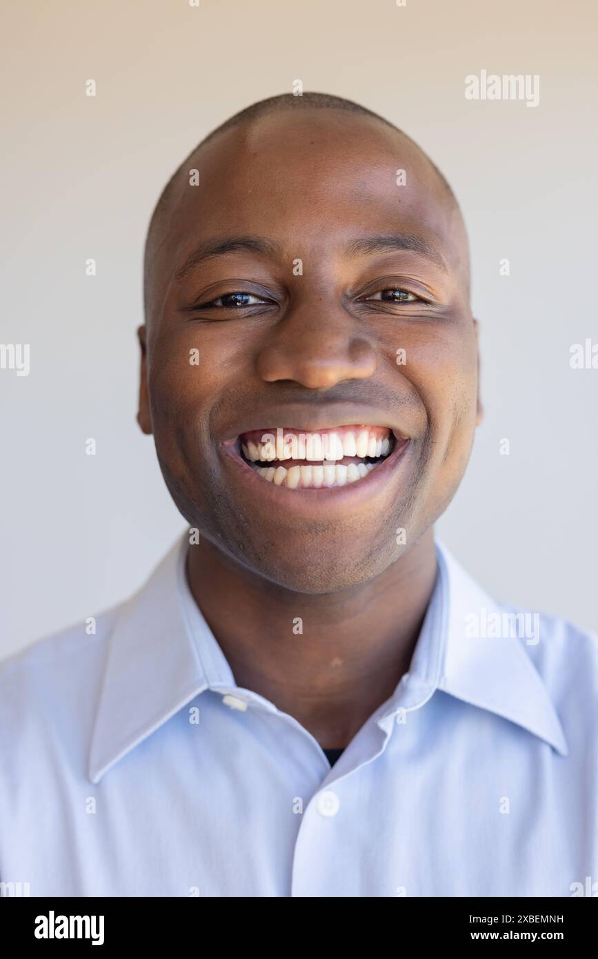 Junger afroamerikanischer Mann, der warm in die Kamera lächelt Stockfoto