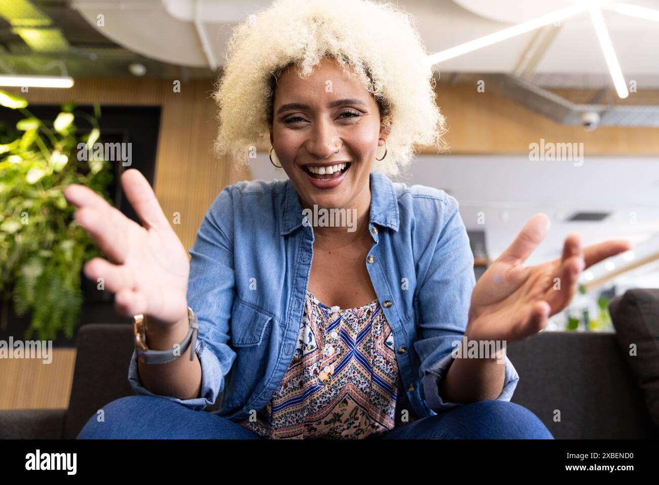 Birassische junge Frau lächelt bei Videogesprächen im Büro Stockfoto