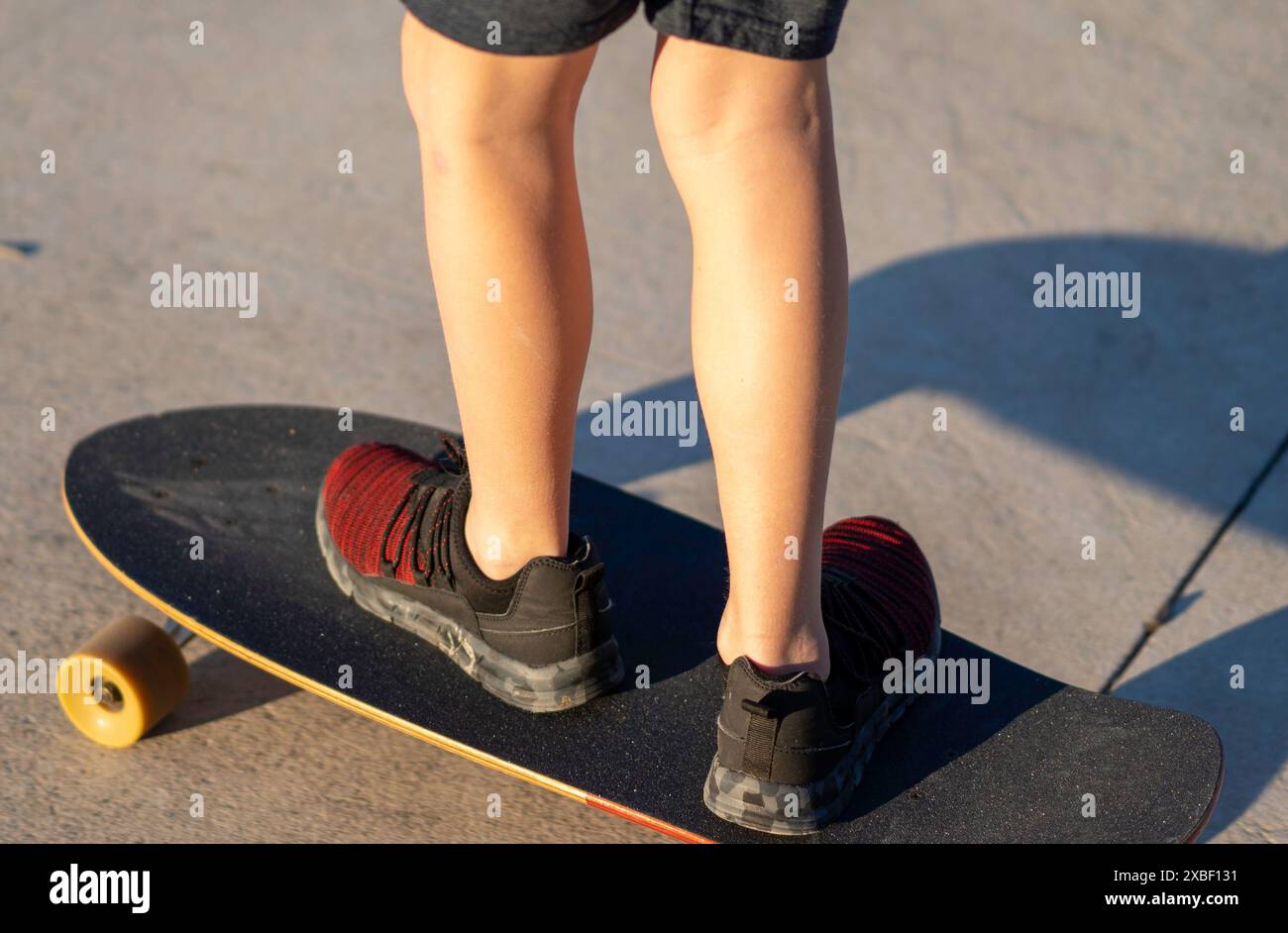 Junger Skater Junge im Park, der sein Skateboard fährt Stockfoto