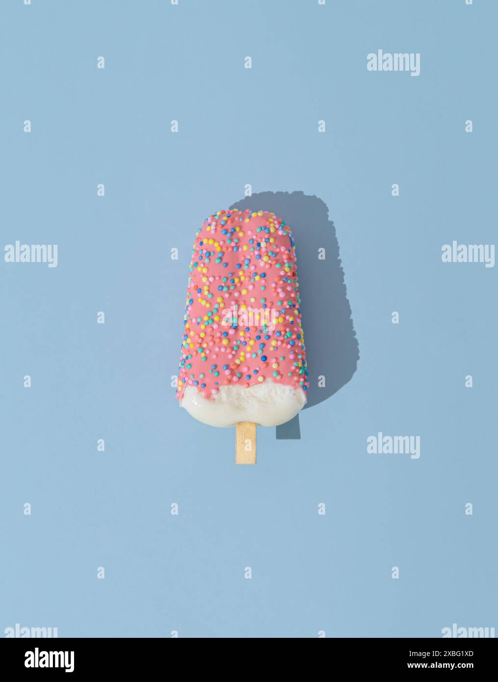 Rosa glasiertes Eis-Eis-Eis auf hellpastellblauem Hintergrund. Minimales Sommerkonzept. Eisästhetik. Flache Lagen. Stockfoto