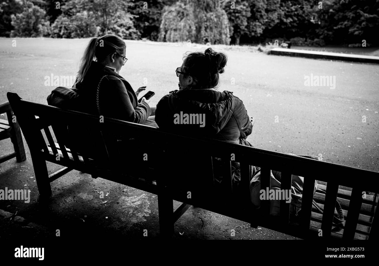 Leute sitzen auf einer Bank in den Princes Street Gardens in Edinburgh, Schottland Stockfoto