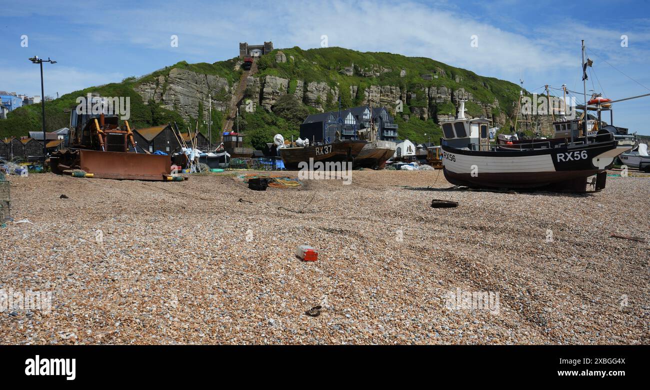 Fischerboote und ein rostiger Bagger am Stade Beach mit East Hill Cliff Railway dahinter. Stockfoto