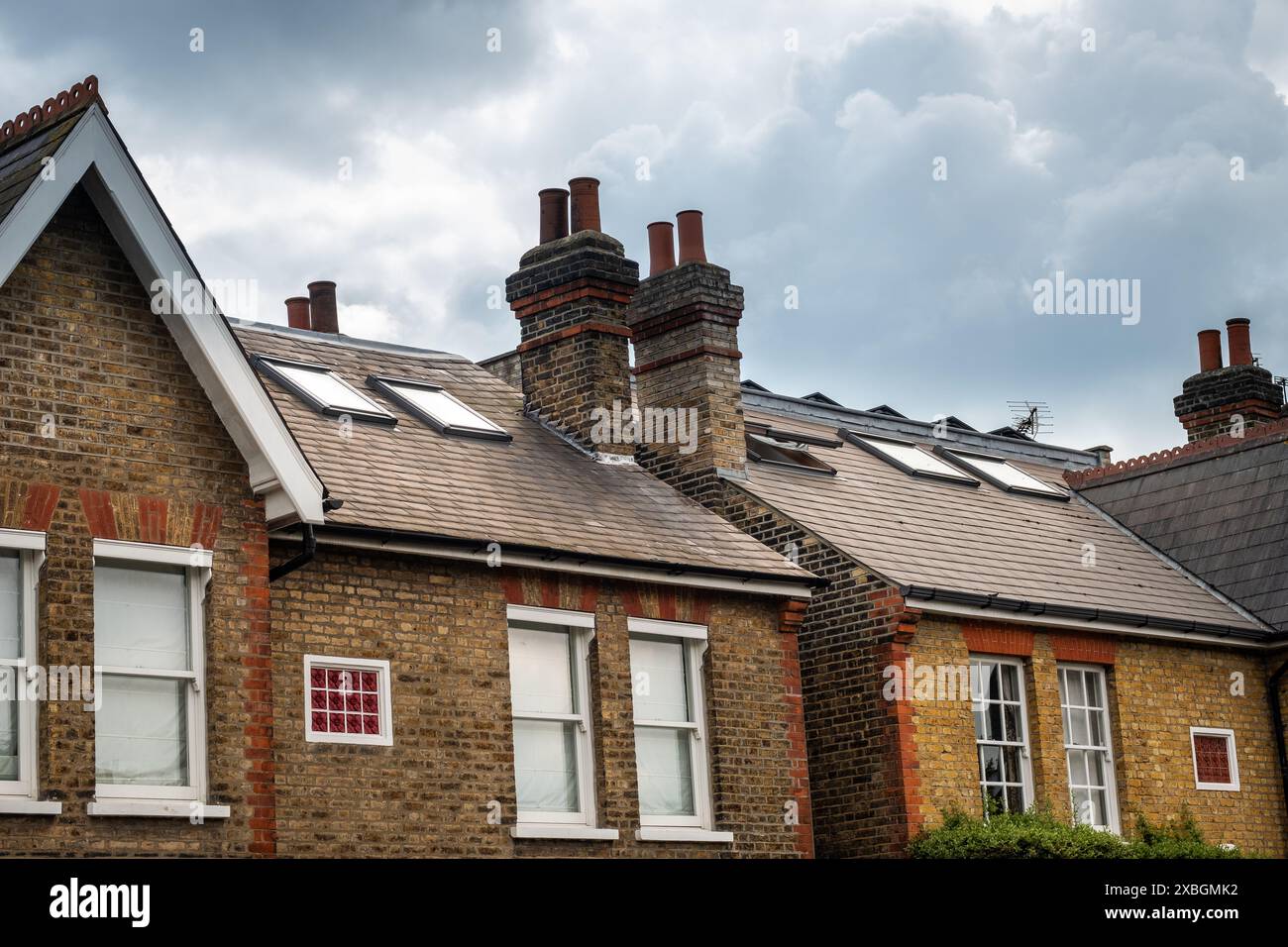 LONDON: Große britische Häuser mit Zimmern, die in die Dachböden eingebaut sind und Dachfenster zeigen Stockfoto