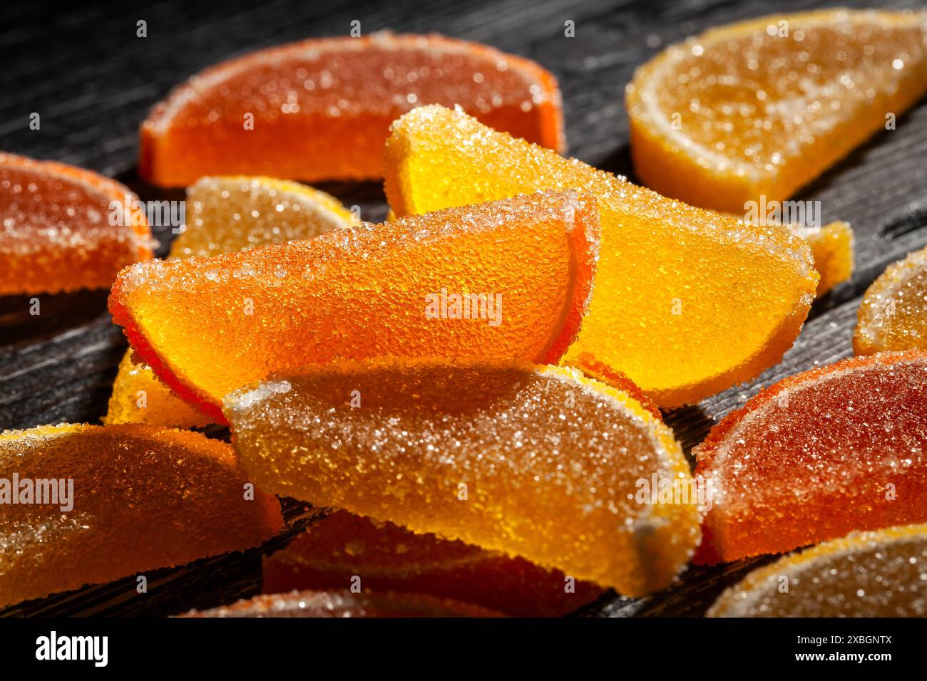 Zitrusbonbons auf schwarzem Holzhintergrund Stockfoto