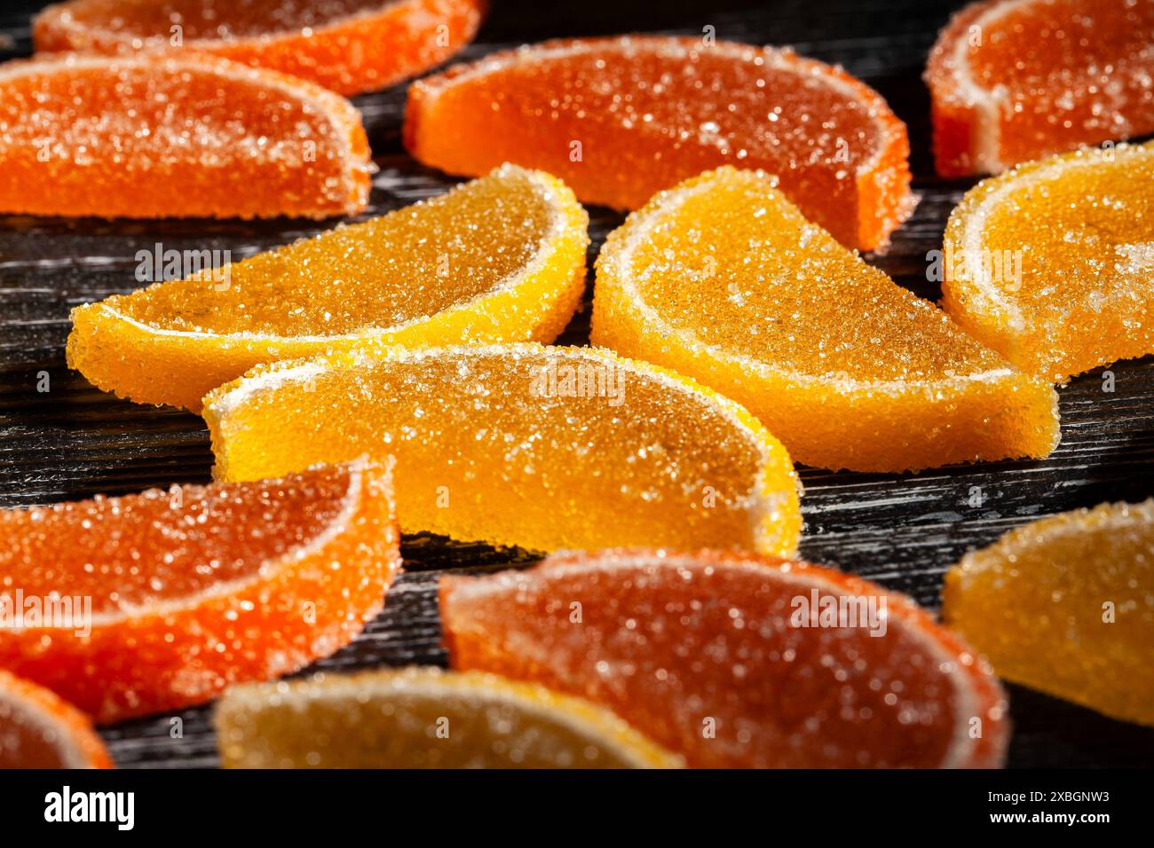 Zitrusbonbons auf schwarzem Holzhintergrund Stockfoto