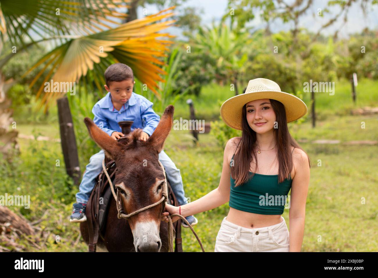 Lebensstil: Weiße Eselhüterin, auf der ihr Bruder mit Down-Syndrom reitet Stockfoto