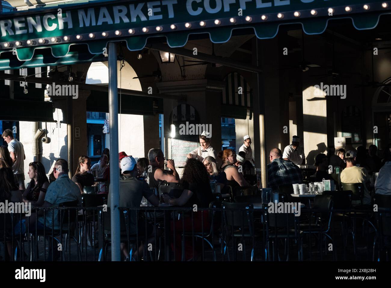 Das ikonische Cafe du Monde im French Quarter von New Orleans, bekannt für seine Beignets und seinen Kaffee, ist voller Gäste, die die lebhafte Atmosphäre genießen. Stockfoto