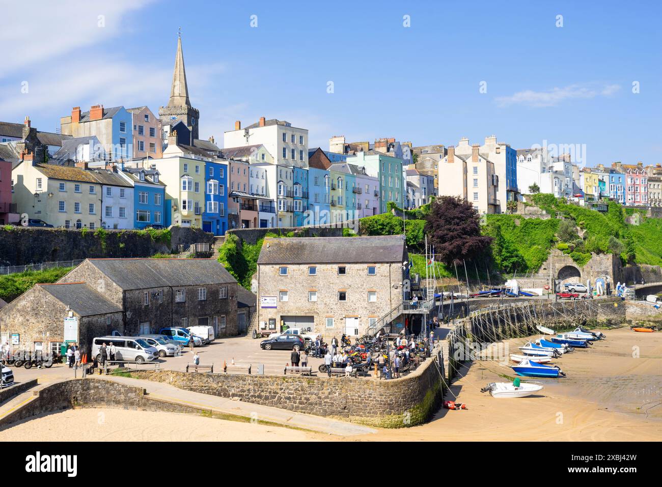 Tenby farbenfrohe Häuser über Tenby Harbour Beach mit kleinen Booten bei Ebbe Tenby Hafen Tenby Carmarthan Bucht Pembrokeshire West Wales UK GB Stockfoto