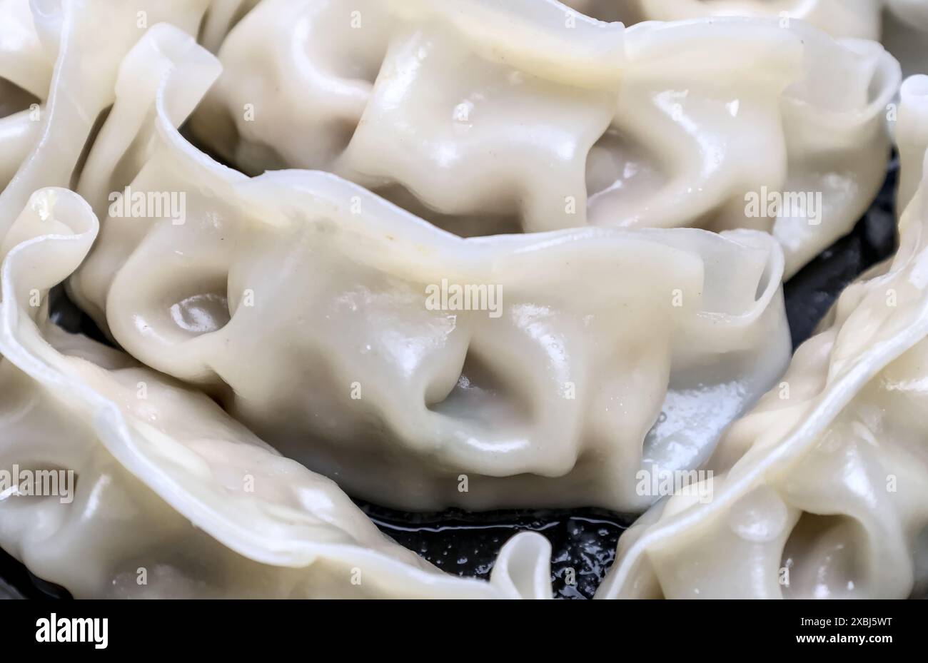 Nahaufnahme chinesischer gedämpfter Teigtaschen in einem Take-away-Behälter (asiatisches Schweinefleisch gefüllt Dim Sum Vorspeise), schwarzer Kunststoff-To Go-Teller-Box (Dampf Do Stockfoto