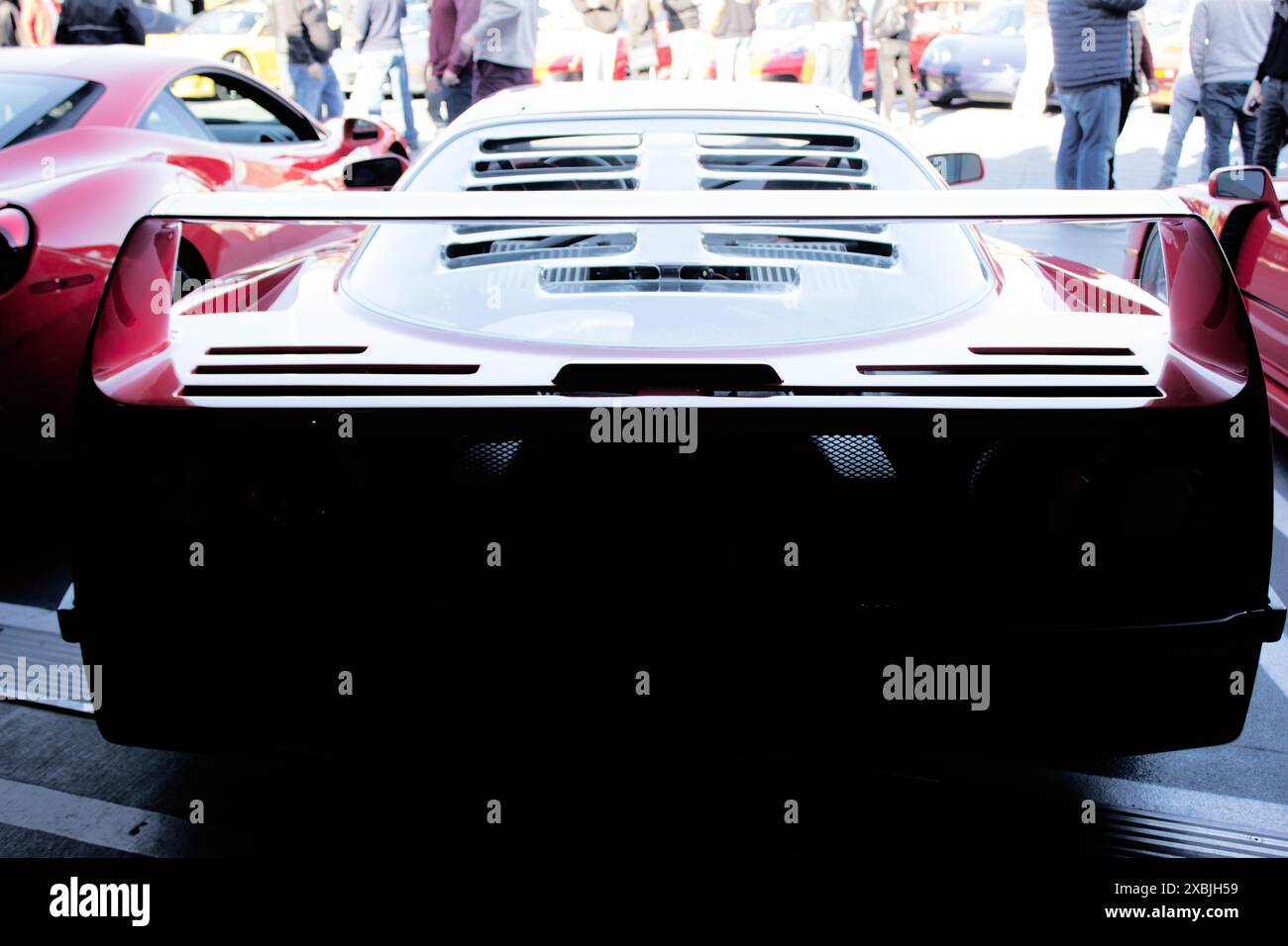 Ein Foto von hinten eines Ferrari F40 mit Details im hinteren Teil, die sich im Schatten einer Parkgarage verstecken und die Morgensonne das Dach hervorheben. Stockfoto