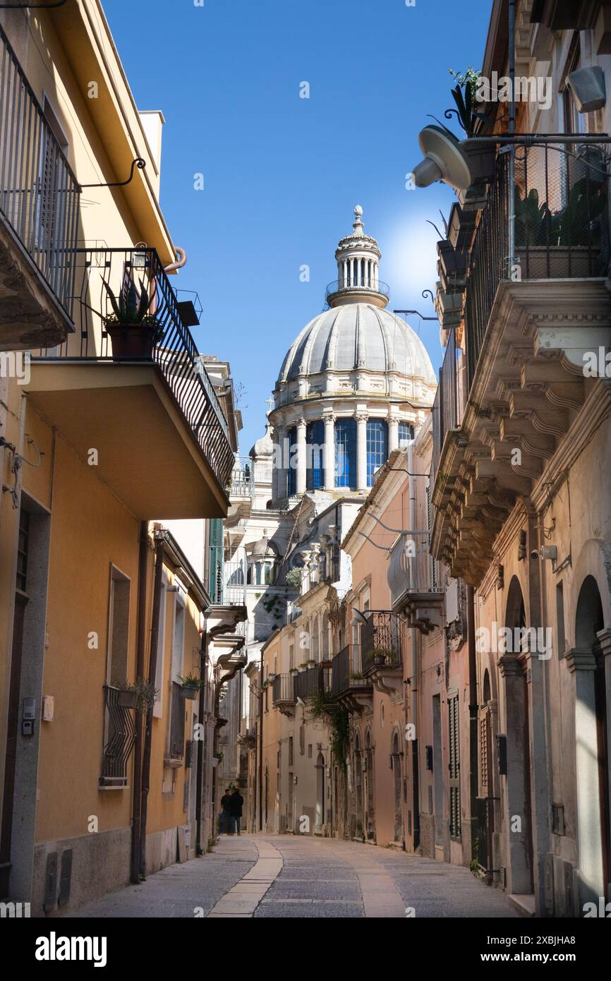 Enge Straße in Ragusa Sizilien mit Blick auf das Kuppeldach des Duomo di San Giogio Regusa, einer historischen baraoque-katholischen Kirche Stockfoto Enge Straße in Ragusa Sizilien mit Blick auf das Kuppeldach des Duomo di San Giogio Regusa, einer historischen baraoque-katholischen Kirche Stockfoto