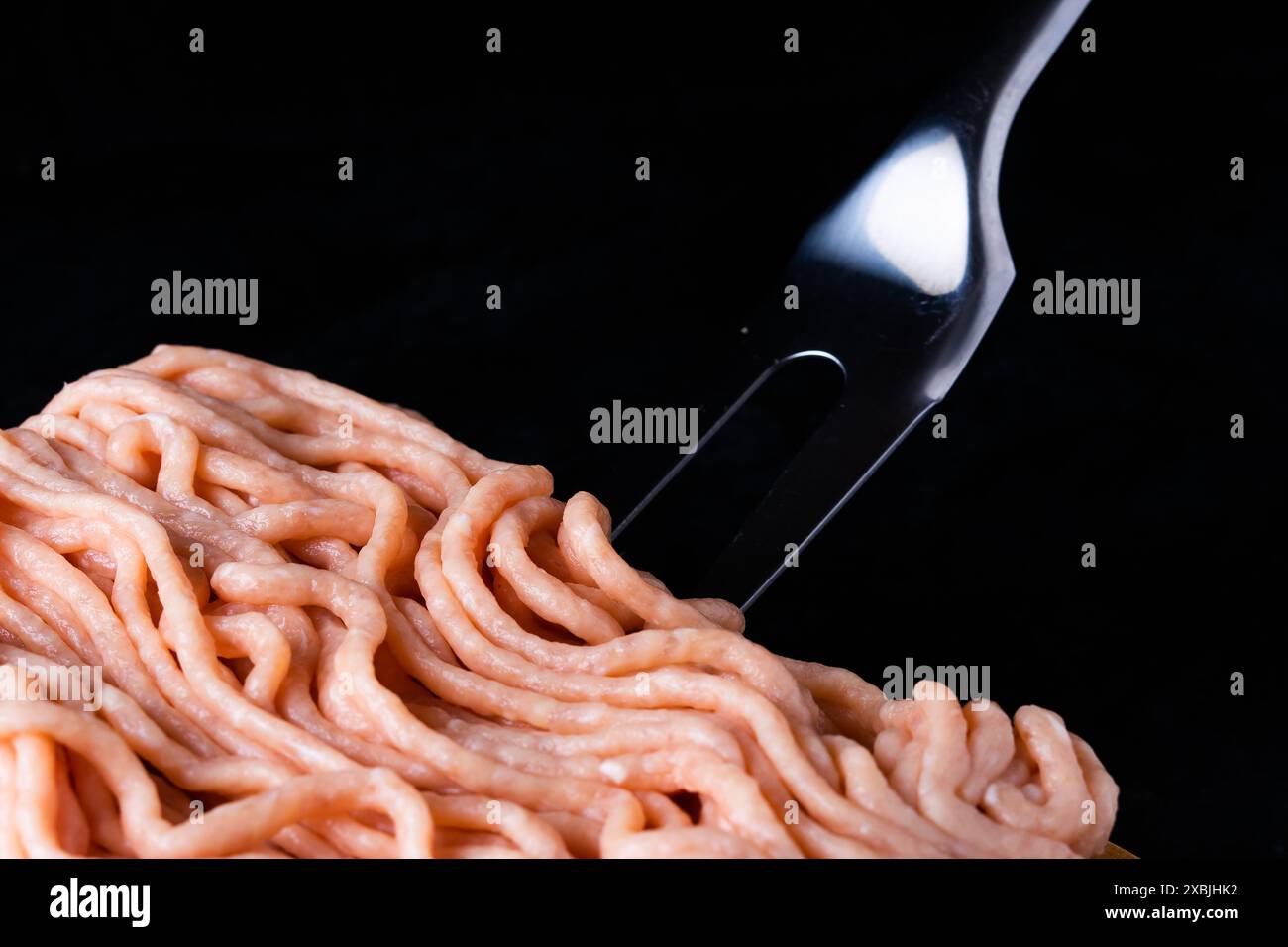 Hackfleisch auf Holz mit einer Gabel. Modisches Foto von Hackfleisch mit Platz für Text. Stockfoto