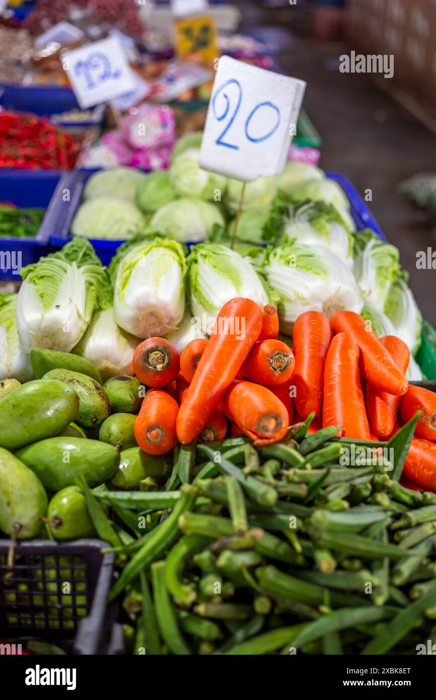 Asiatischer Gemüsemarkt. Karotten und Chinakohl mit Preisschildern auf der Theke. Stockfoto