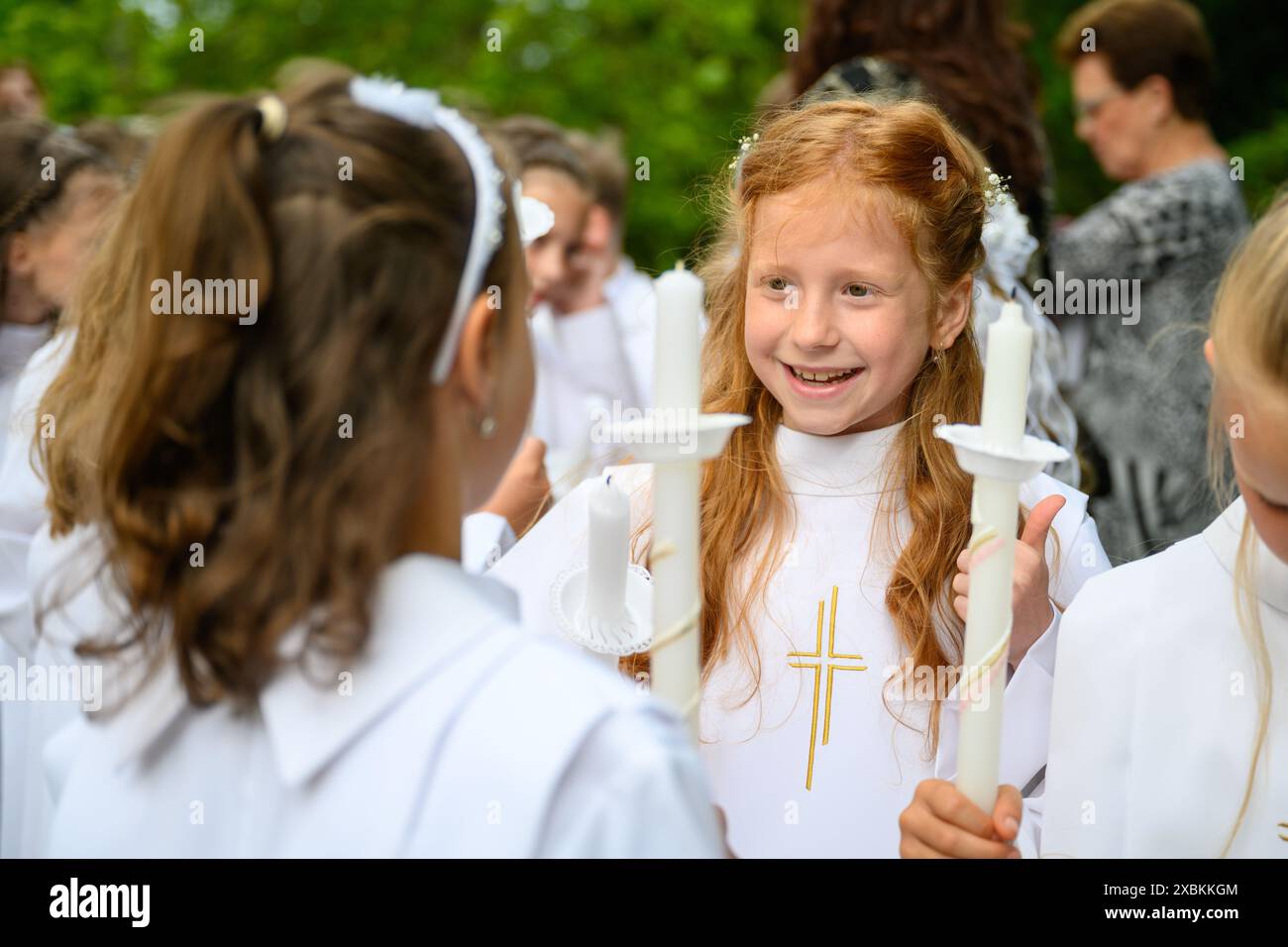 Kinder, die vor ihrer ersten Kommunionmesse sprechen. Stockfoto