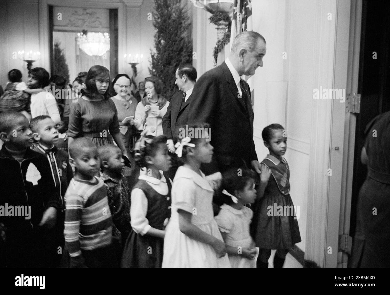 US-Präsident Lyndon Johnson begleitet Kinder der Armut bei einer Party im Weißen Haus, Washington, D.C., USA, Marion S. Trikosko, U.S. News & World Report Magazine Photograph Collection, 16. Dezember 1964 Stockfoto
