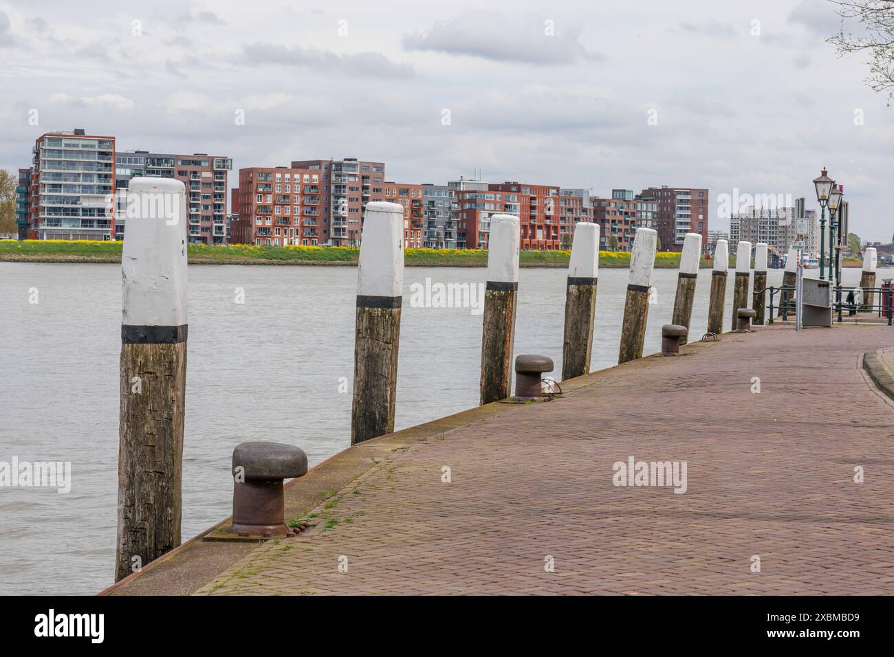 Flussufer mit weißen Pfählen und modernen Gebäuden entlang der Promenade, Dordrecht, holland, niederlande Stockfoto