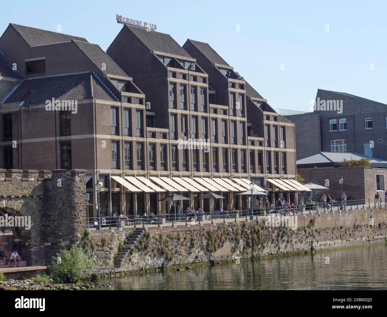 Ein modernes architektonisches Gebäude am Fluss mit einer sonnigen Terrasse und reflektierendem Wasser, Maastricht, limburg, niederlande Stockfoto