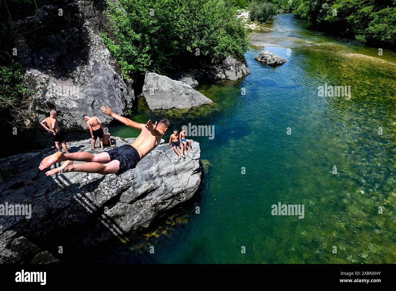 Skopje, Nordmazedonien. Juni 2024. Am 12. Juni 2024 springt ein Mann in den Treska, um sich von der Hitze in der Nähe des Dorfes Matka, westlich der Hauptstadt Skopje, in Nordmazedonien, abzukühlen. Quelle: Tomislav Georgiev/Xinhua/Alamy Live News Stockfoto