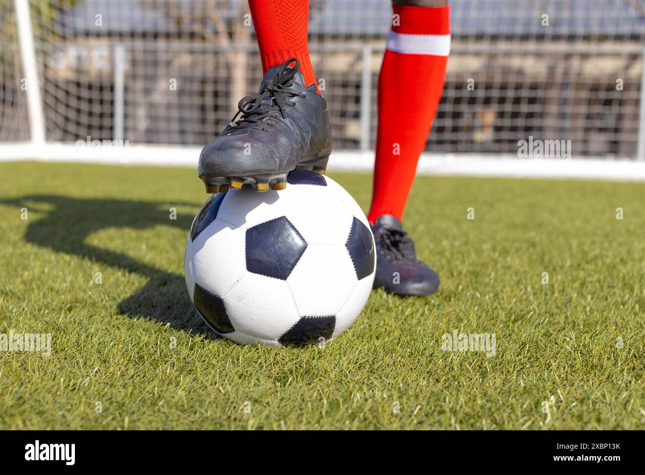 Afroamerikaner trainiert mit Fußball auf dem Spielfeld Stockfoto