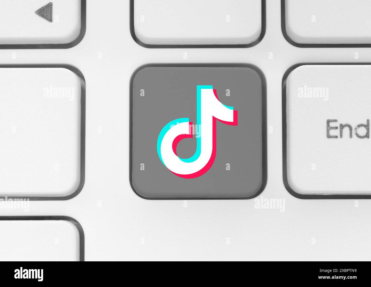 TikTok-Symboltaste auf einer weißen Computertastatur Nahaufnahme. Konzept des Arbeitsprozesses in populären Social Media-Diensten. TikTok ist ein Kurzform-Video-Hosti Stockfoto