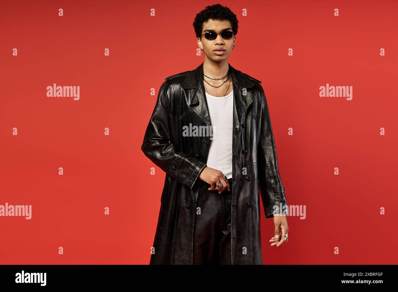 Schöner afroamerikanischer Mann in schwarzem Trenchcoat und Sonnenbrille. Stockfoto