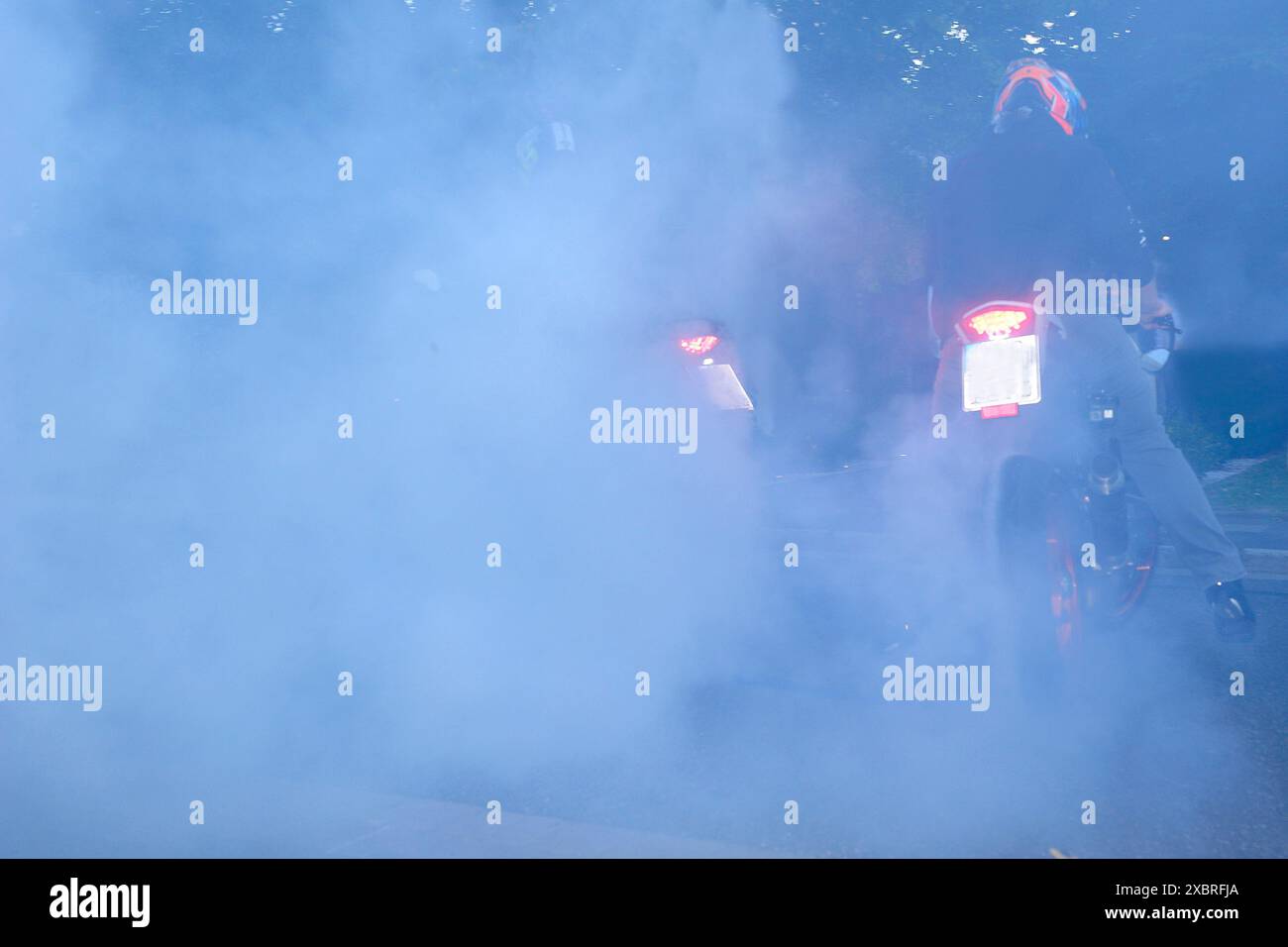 Motorrad, Bravado, Wahnsinn auf der Straße, Fahrt, Gummi, Straße, keine Grenze, Radreifen, brennendes Gummi, brennendes Gummi auf dem Asphalt, Straßenrennen, Verfolger Stockfoto