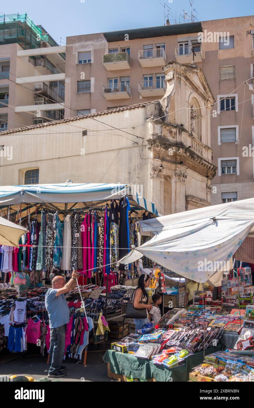 Der geschäftige tägliche Markt von Fera' o Luni in Catania, Sizilien, mit der winzigen barocken Kirche San Gaetano alle Grotte im Hintergrund Stockfoto